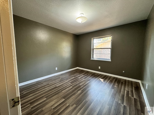 unfurnished room featuring dark wood-type flooring and a textured ceiling