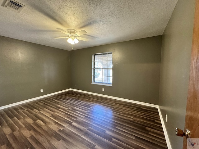 spare room featuring ceiling fan, dark wood-type flooring, and a textured ceiling