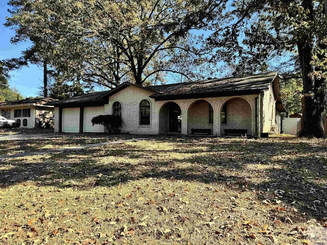 ranch-style house featuring a garage and a front lawn