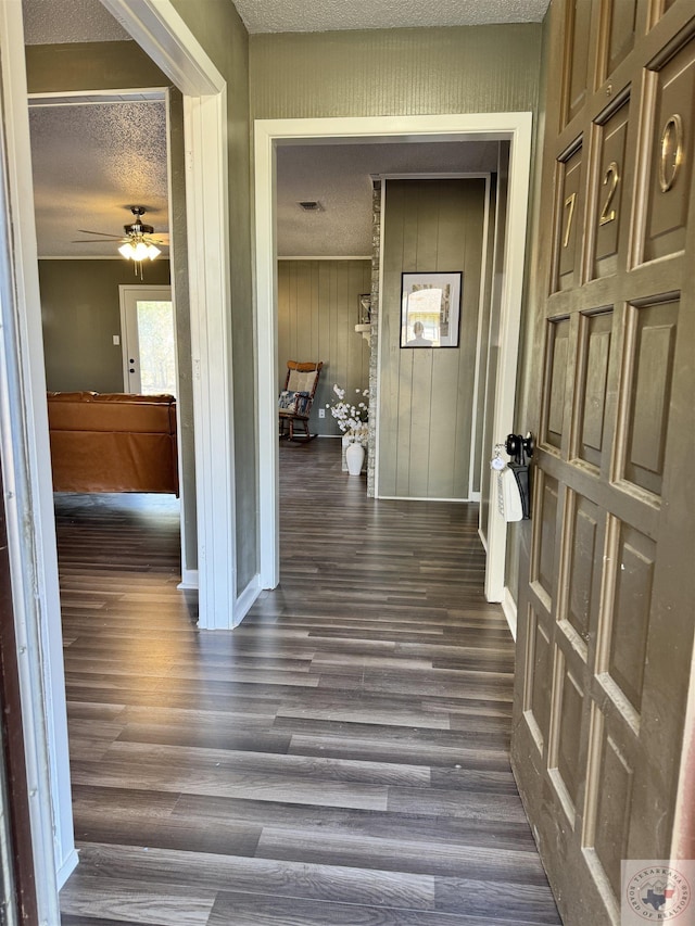 hall featuring a textured ceiling and dark hardwood / wood-style flooring