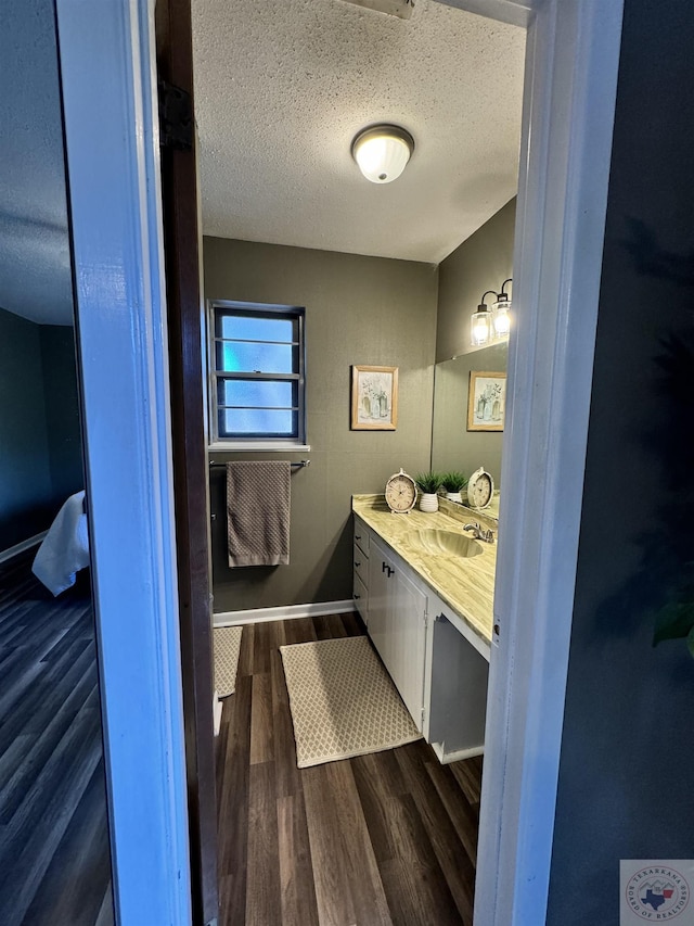 bathroom with hardwood / wood-style floors, a textured ceiling, and vanity