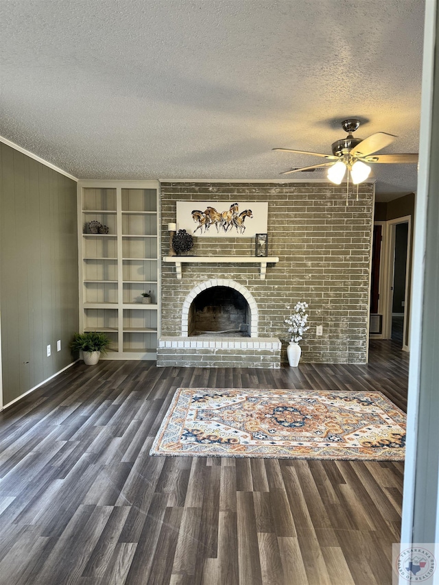 unfurnished living room with a brick fireplace, dark hardwood / wood-style floors, and a textured ceiling