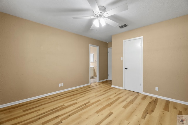 unfurnished bedroom featuring ceiling fan, ensuite bathroom, and light hardwood / wood-style flooring