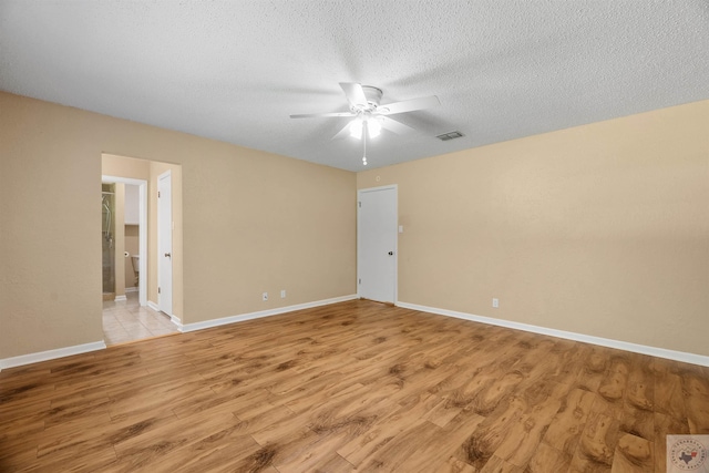 spare room with light hardwood / wood-style floors, a textured ceiling, and ceiling fan