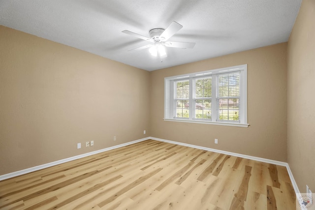 spare room featuring light wood-type flooring, a textured ceiling, and ceiling fan