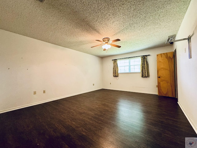 spare room with ceiling fan, a textured ceiling, and dark hardwood / wood-style flooring