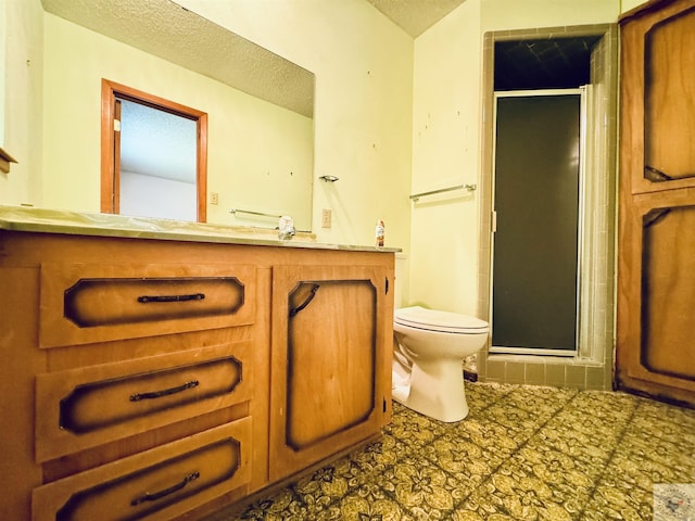 bathroom with a textured ceiling, toilet, a shower with door, and vanity