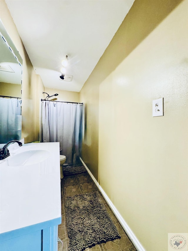 bathroom featuring curtained shower, vanity, and toilet