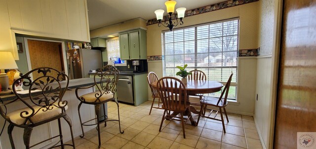 dining room with light tile patterned flooring, plenty of natural light, and a chandelier