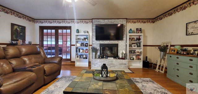 living room featuring hardwood / wood-style flooring, french doors, ceiling fan, and a fireplace