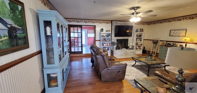 living room featuring a fireplace, wood-type flooring, and ceiling fan