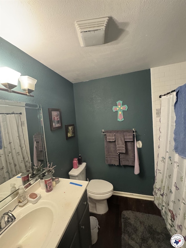 310 W Greenfield Dr, Wake Village, TX 75501 - bathroom featuring vanity, toilet, a shower with shower curtain, a textured ceiling, and wood finished floors
