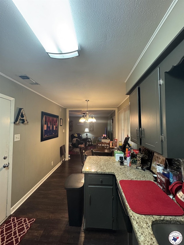 310 W Greenfield Dr, Wake Village, TX 75501 - kitchen featuring ornamental molding, dark wood-type flooring, a peninsula, a textured ceiling, and decorative light fixtures