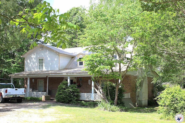 1750 County Road 4152, Simms, TX 75574 - view of front facade with a porch, a front yard, and brick siding