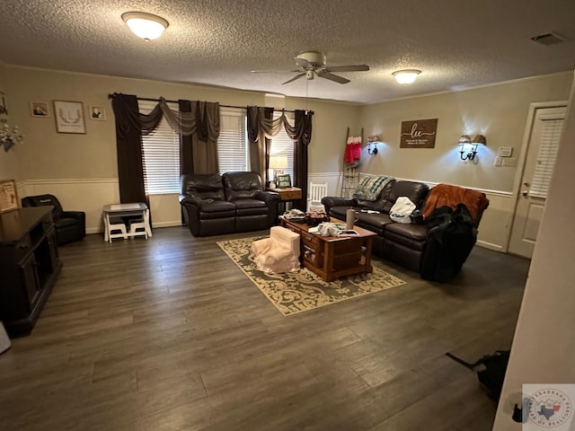 living room featuring a textured ceiling, dark hardwood / wood-style floors, ceiling fan, and ornamental molding