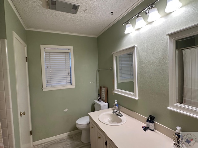 bathroom featuring vanity, toilet, crown molding, and a textured ceiling