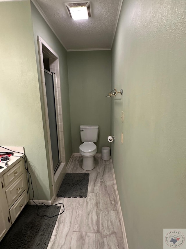 bathroom featuring toilet, a textured ceiling, and an enclosed shower