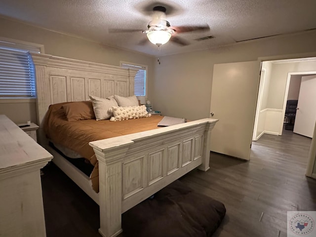 bedroom with a textured ceiling, dark hardwood / wood-style floors, and ceiling fan