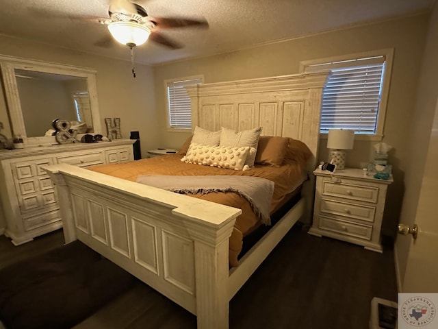 bedroom with ceiling fan, dark wood-type flooring, and a textured ceiling