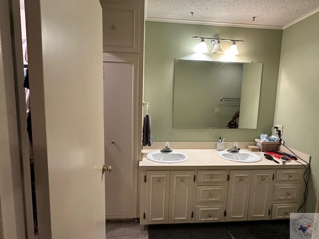 bathroom with crown molding, a textured ceiling, and vanity