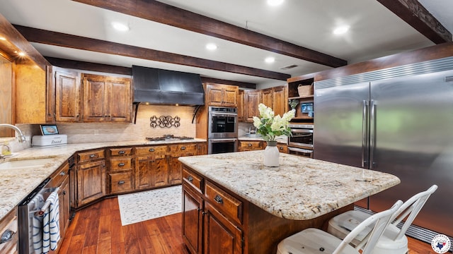10 High Point Dr, Texarkana, TX 75503 - kitchen with stainless steel appliances, custom exhaust hood, dark wood finished floors, beamed ceiling, and light stone countertops