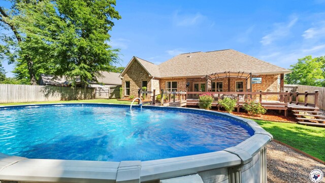 view of swimming pool featuring a wooden deck, a fenced in pool, and a fenced backyard