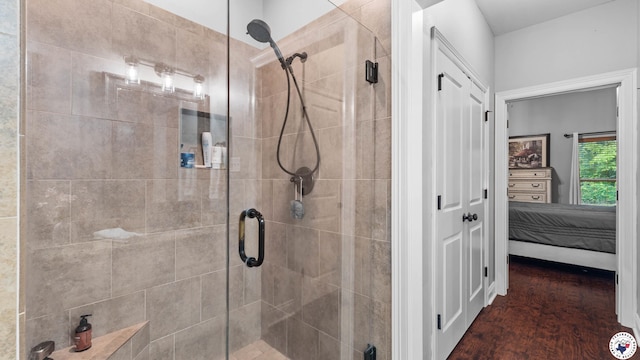 bathroom with ensuite bathroom, wood finished floors, and a stall shower