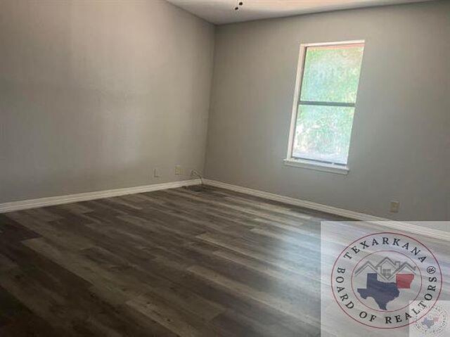 spare room with dark wood-type flooring