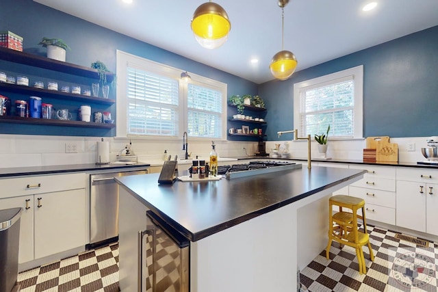 kitchen with dishwasher, a kitchen breakfast bar, white cabinets, pendant lighting, and beverage cooler