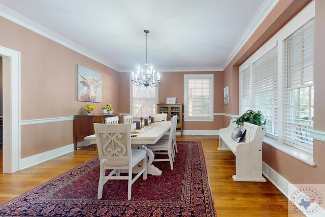 dining room featuring light hardwood / wood-style floors, crown molding, and a notable chandelier