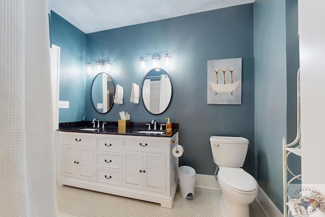 bathroom with toilet, vanity, and tile patterned flooring