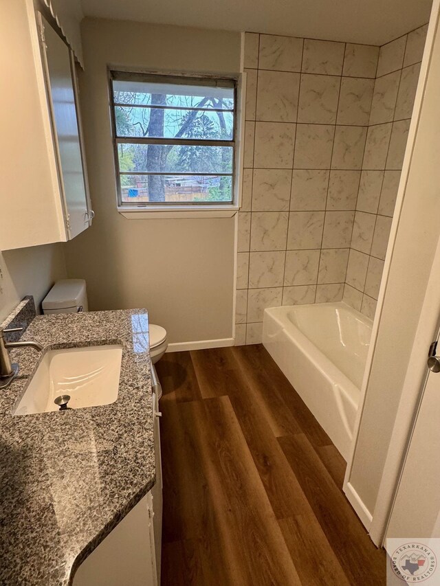 full bath featuring baseboards, toilet, vanity, and wood finished floors