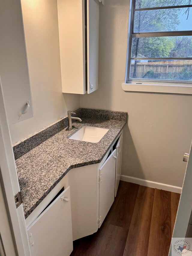 bathroom with baseboards, wood finished floors, and vanity