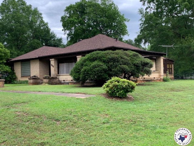 view of front of house with a front yard and brick siding