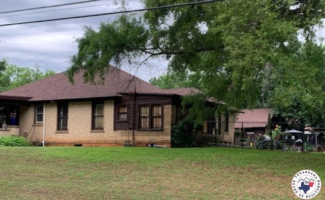 rear view of house featuring a yard, brick siding, fence, and crawl space