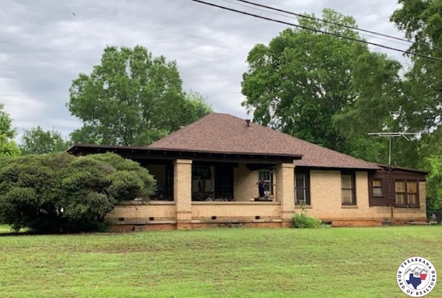 exterior space with a yard, brick siding, a shingled roof, and crawl space