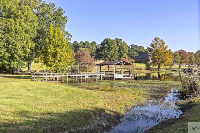 view of dock with a water view and a yard