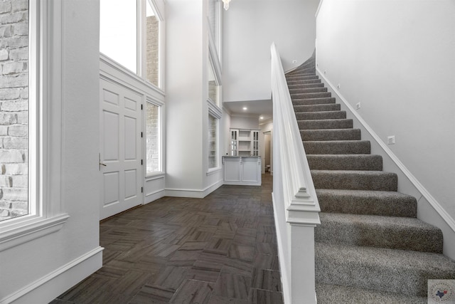 foyer featuring a high ceiling and dark parquet flooring