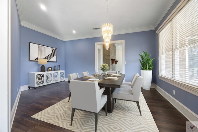 dining area with a notable chandelier, crown molding, and dark hardwood / wood-style floors