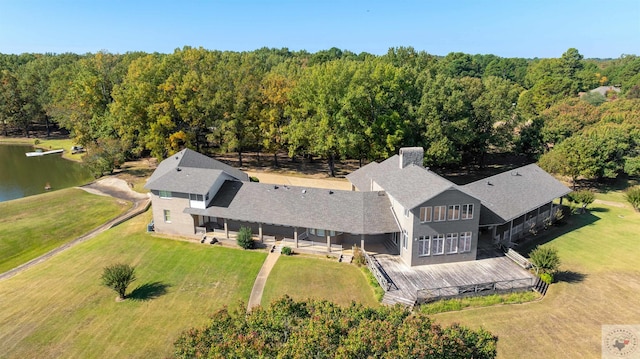 birds eye view of property with a water view and a view of trees