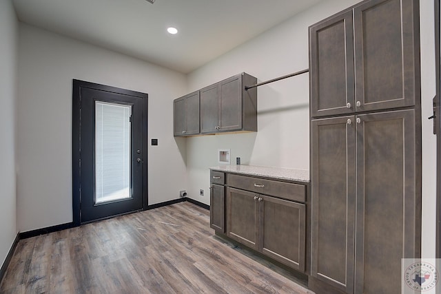 washroom featuring washer hookup, hardwood / wood-style flooring, electric dryer hookup, and cabinets