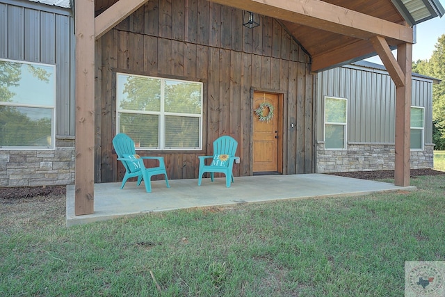 entrance to property with a patio area and a yard