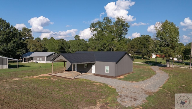 exterior space with a carport and a lawn