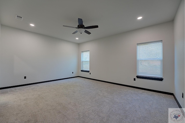 carpeted spare room with ceiling fan and a wealth of natural light