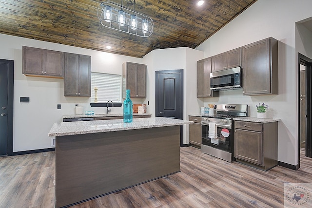 kitchen featuring stainless steel appliances, a kitchen island, dark hardwood / wood-style floors, and pendant lighting