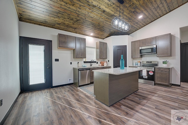 kitchen featuring a center island, appliances with stainless steel finishes, hanging light fixtures, dark brown cabinets, and dark wood-type flooring