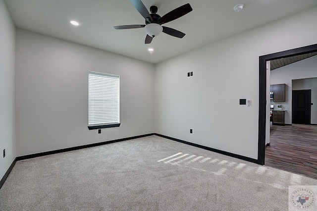 carpeted spare room featuring ceiling fan