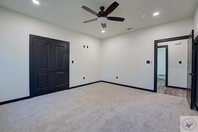 unfurnished bedroom with light colored carpet, a closet, and ceiling fan