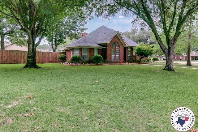 ranch-style home featuring brick siding, fence, a chimney, and a front yard