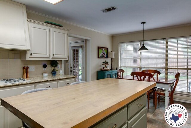 kitchen featuring white cabinetry, butcher block counters, visible vents, and white gas stovetop
